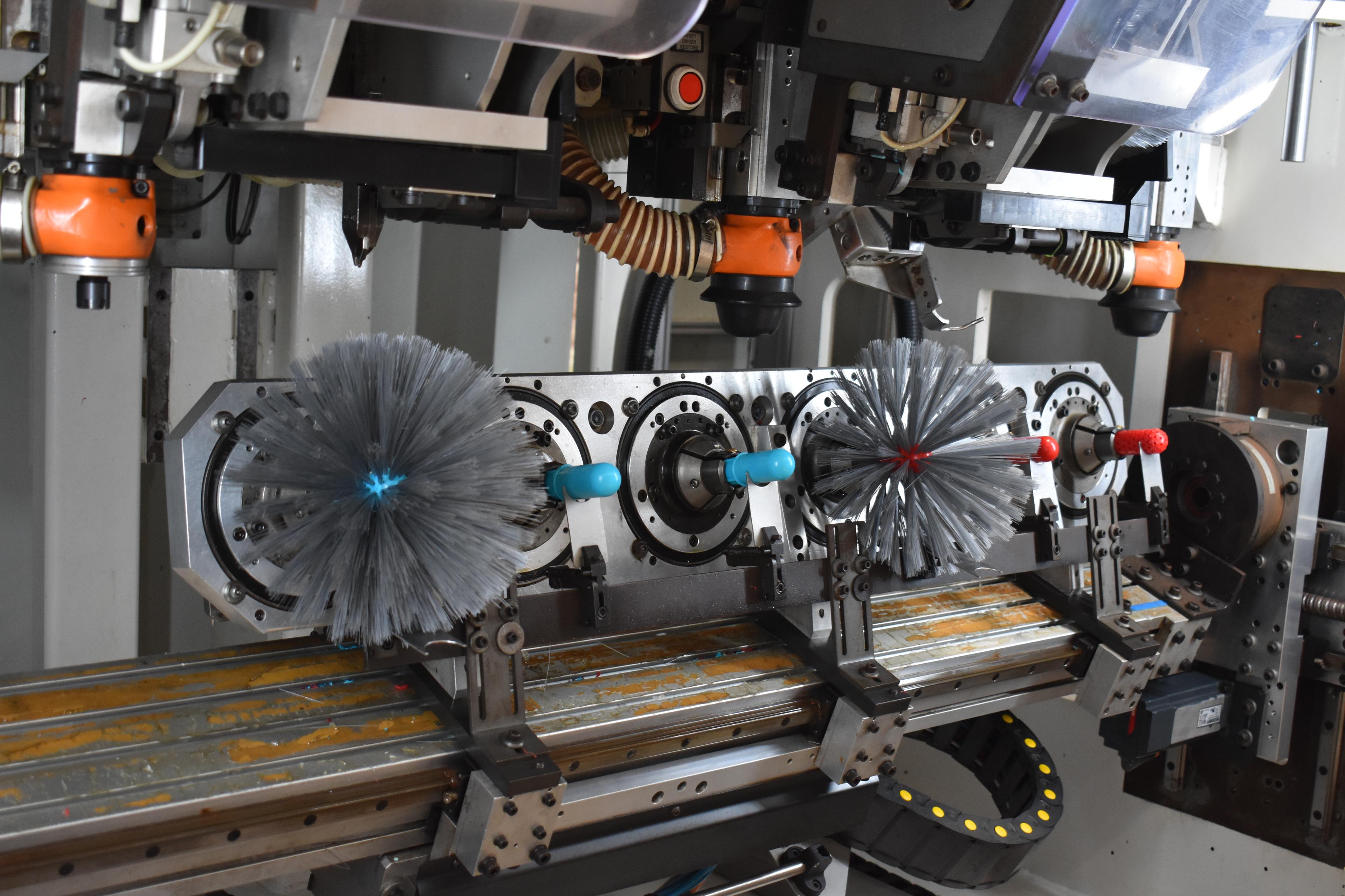Brush manufacturing machine with orange components